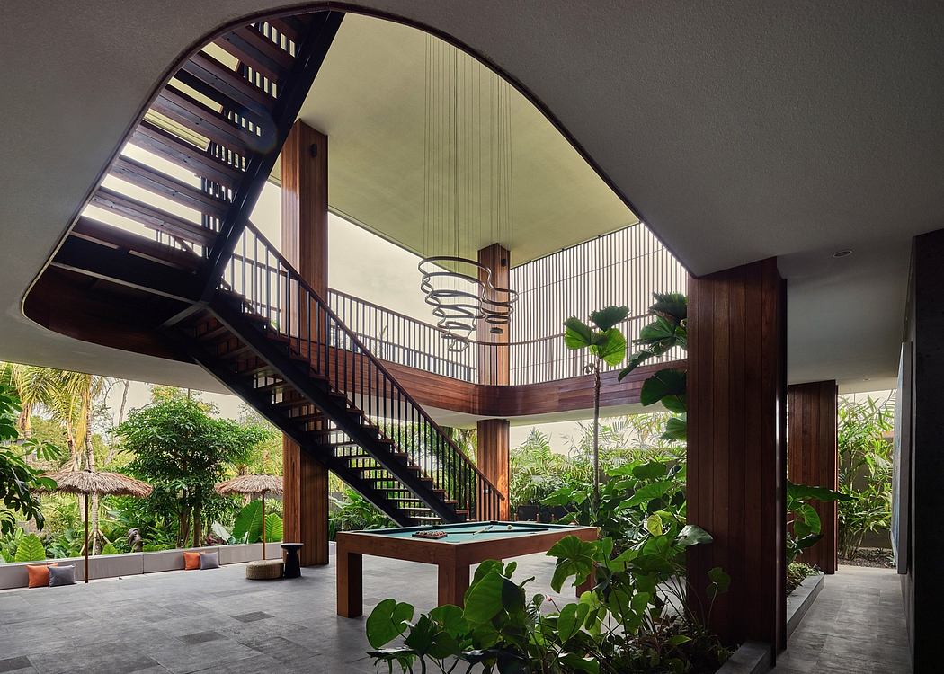 A modern, open-plan interior with a dramatic spiral staircase, lush greenery, and a pond.