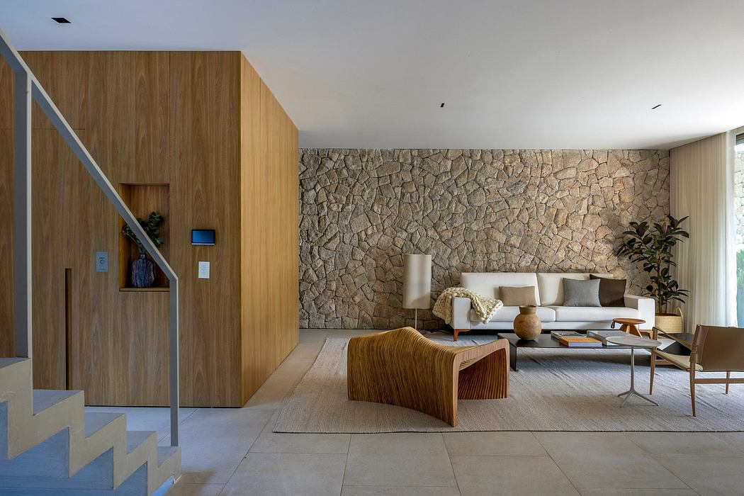Warm, modern living space featuring wooden paneling, stone wall, and minimalist furniture.