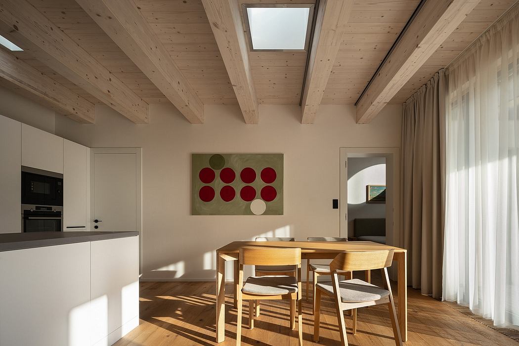 A spacious, modern dining room with wooden beams, natural lighting, and artwork on the walls.