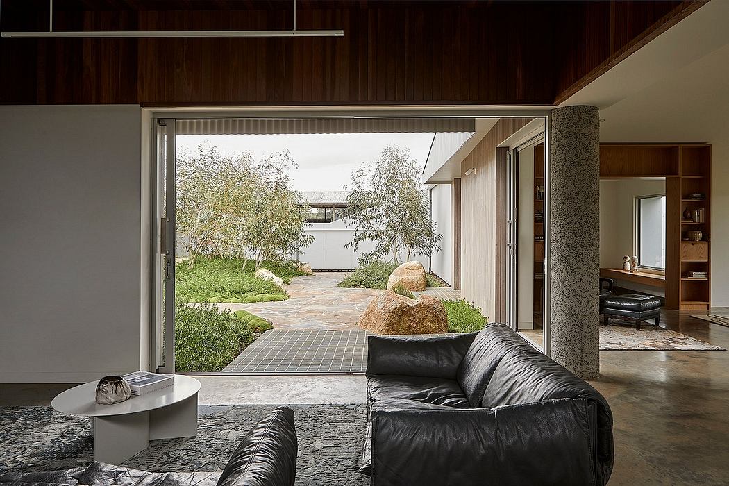 Sleek modern interior with floor-to-ceiling windows overlooking lush garden landscape.