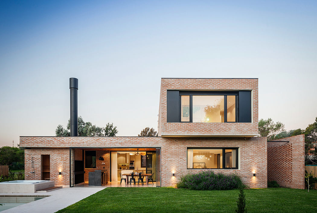 Modern two-story home with brick exterior, large windows, and outdoor dining area.