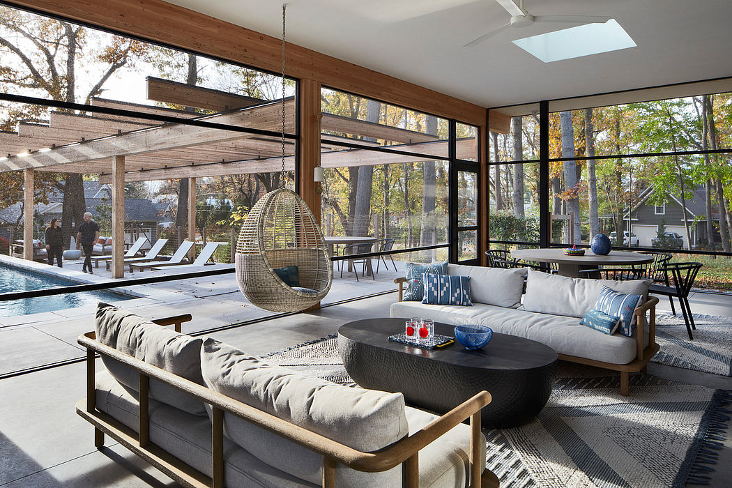 Cozy outdoor living area with panoramic windows, suspended seating, and modern furnishings.