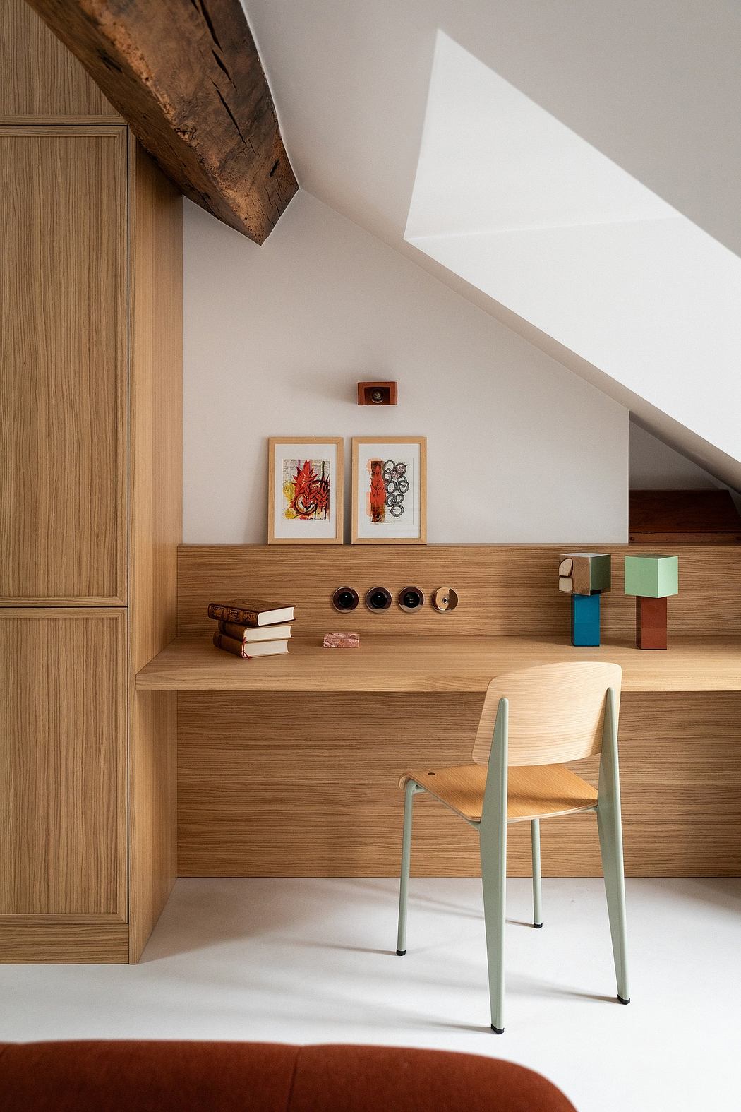 Cozy workspace with rustic wood beams, minimalist shelving, and colorful accents.