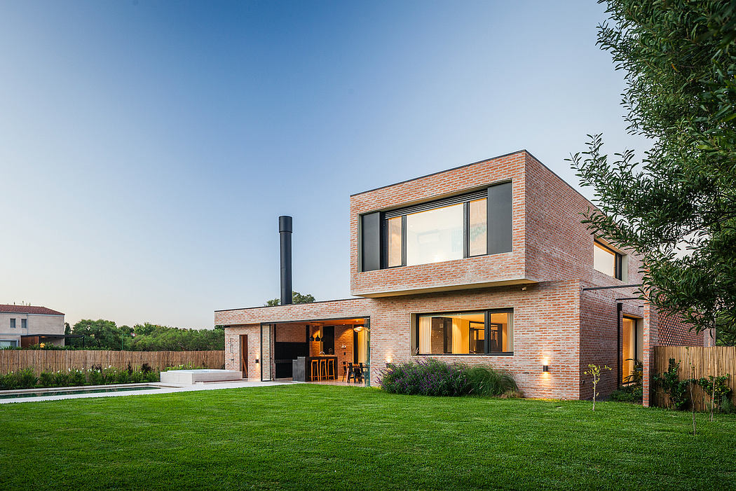Striking modern home with brick exterior, large windows, and expansive lawn.