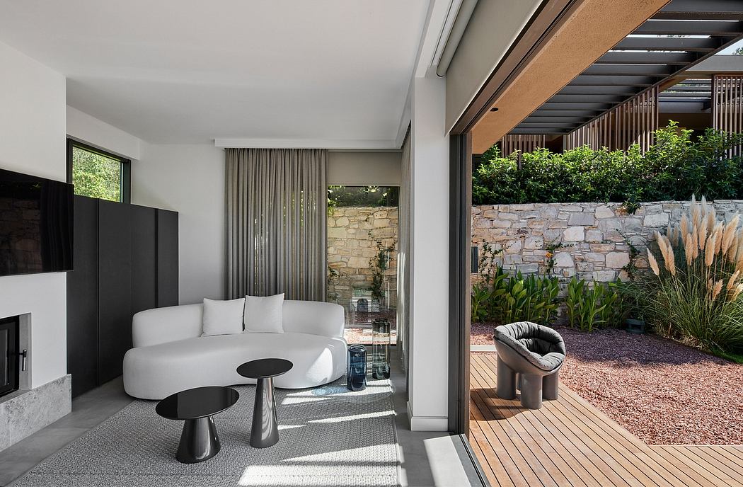 Modern living room with large sliding glass doors, wood and stone accents, and outdoor patio.