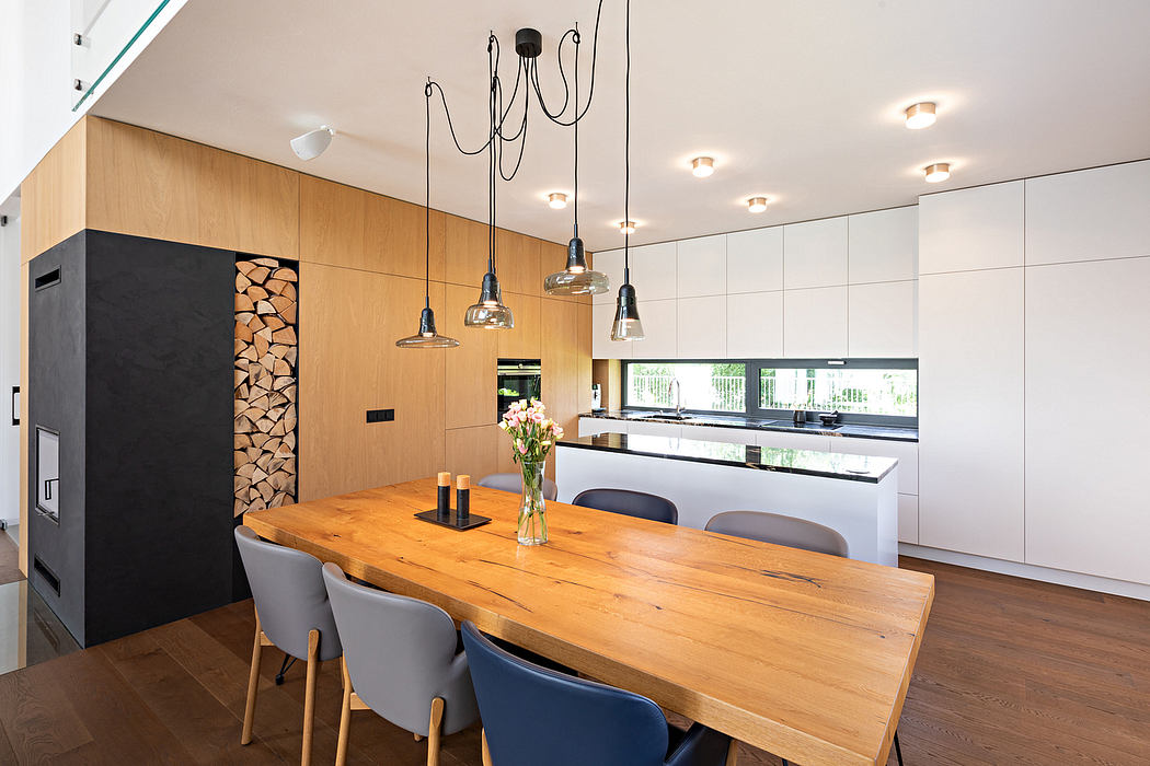 Sleek modern kitchen with wooden dining table, pendant lighting, and integrated appliances.