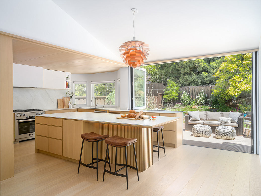 Bright, modern kitchen with wooden cabinetry, sleek island, and pendant light fixture.