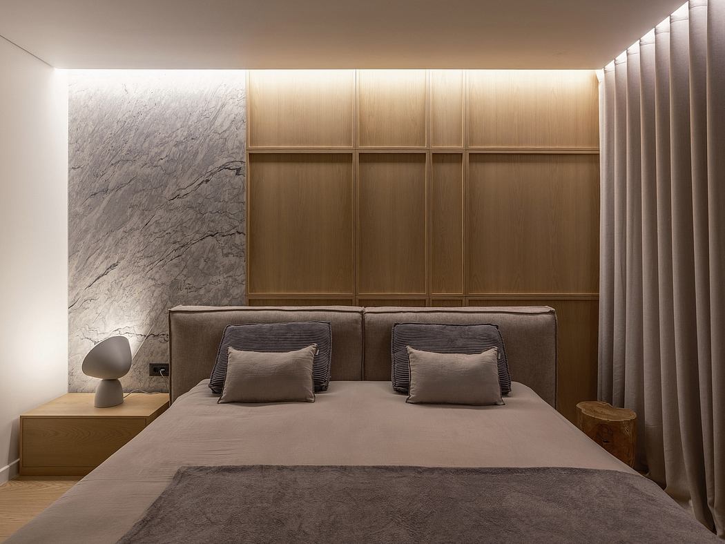 Elegant bedroom with grey marble feature wall, wooden cabinetry, and modern lighting.