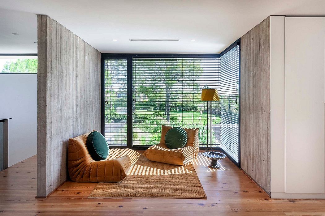 A modern interior with wood paneled walls, plush seating, and floor-to-ceiling windows offering a scenic view.