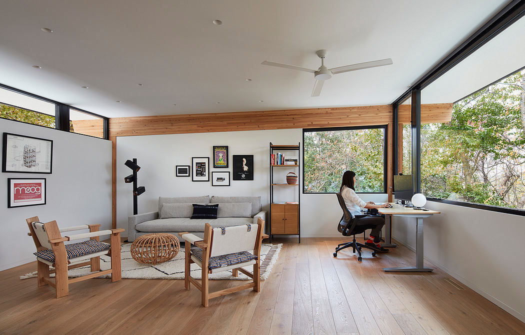 Modern open-plan living space with wooden accents, minimalist furnishings, and panoramic windows offering natural views.