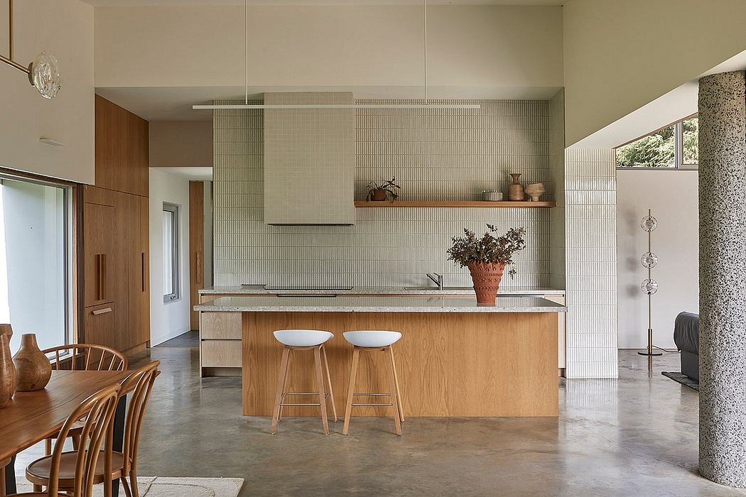Modern kitchen with sleek wood cabinetry, concrete floors, and a minimalist island.