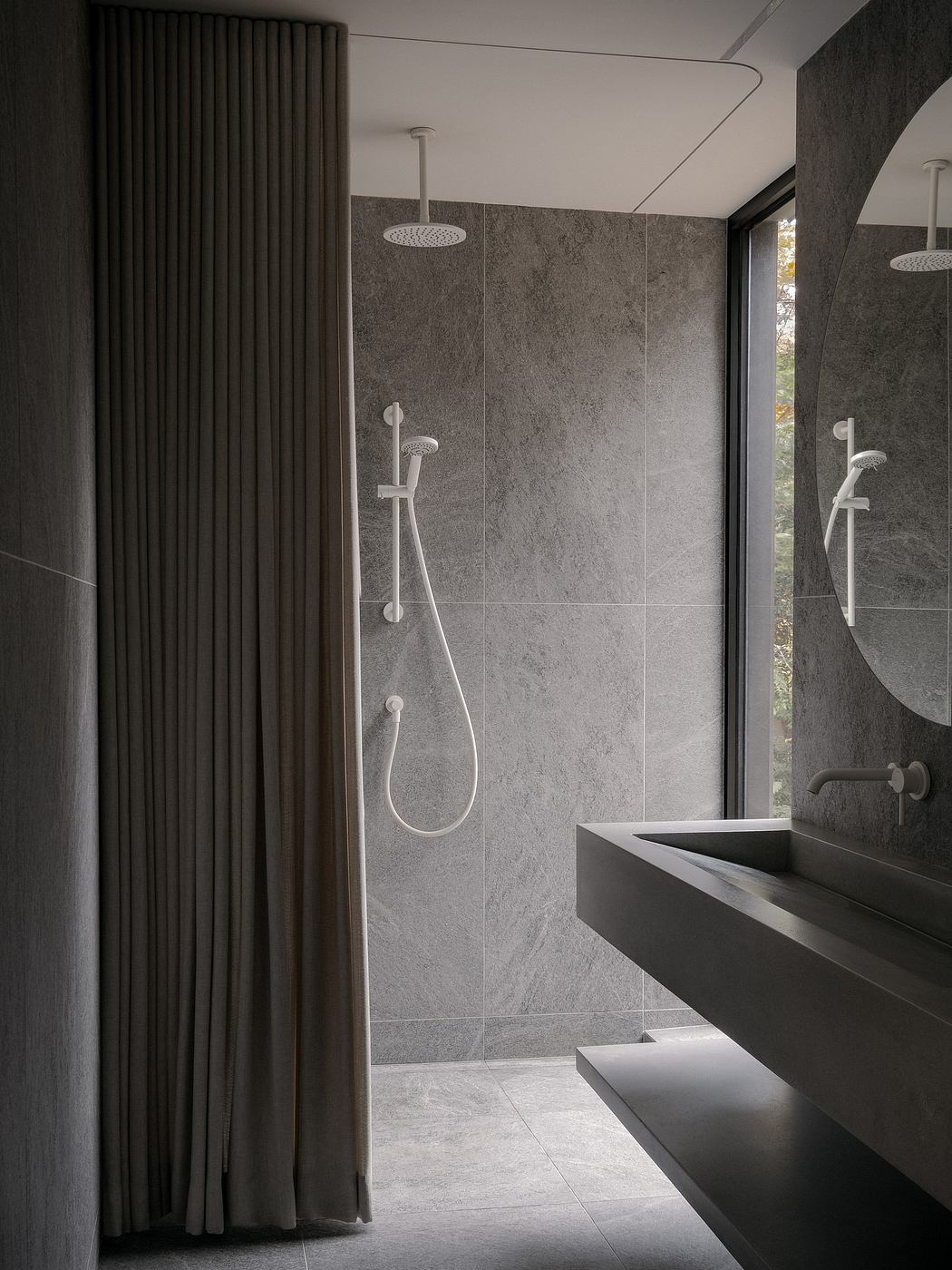 Sleek, minimalist bathroom with gray tiles, rainfall showerheads, and a modern vanity.