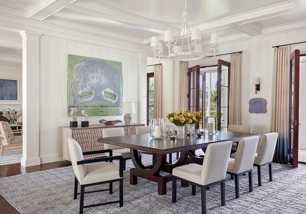 Elegant dining room with high ceilings, large artwork, and a dark wood dining table.