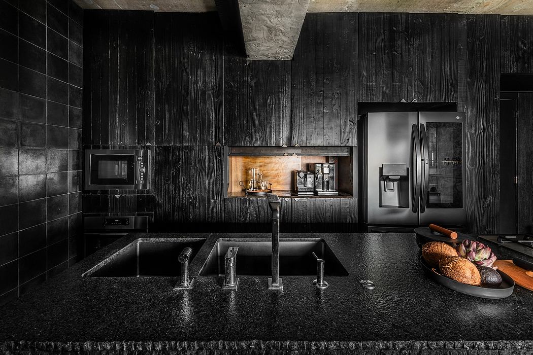 A modern, dark-themed kitchen with wooden accents, black appliances, and a double sink.