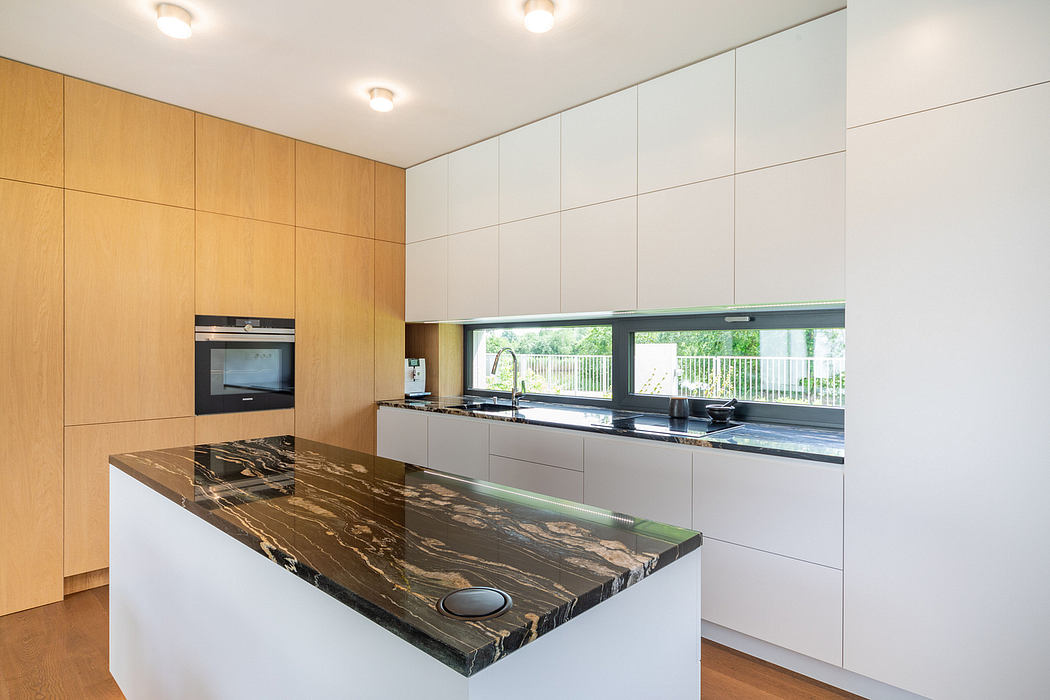 Modern minimalist kitchen with wood panel walls, built-in appliances, and sleek marble countertop.