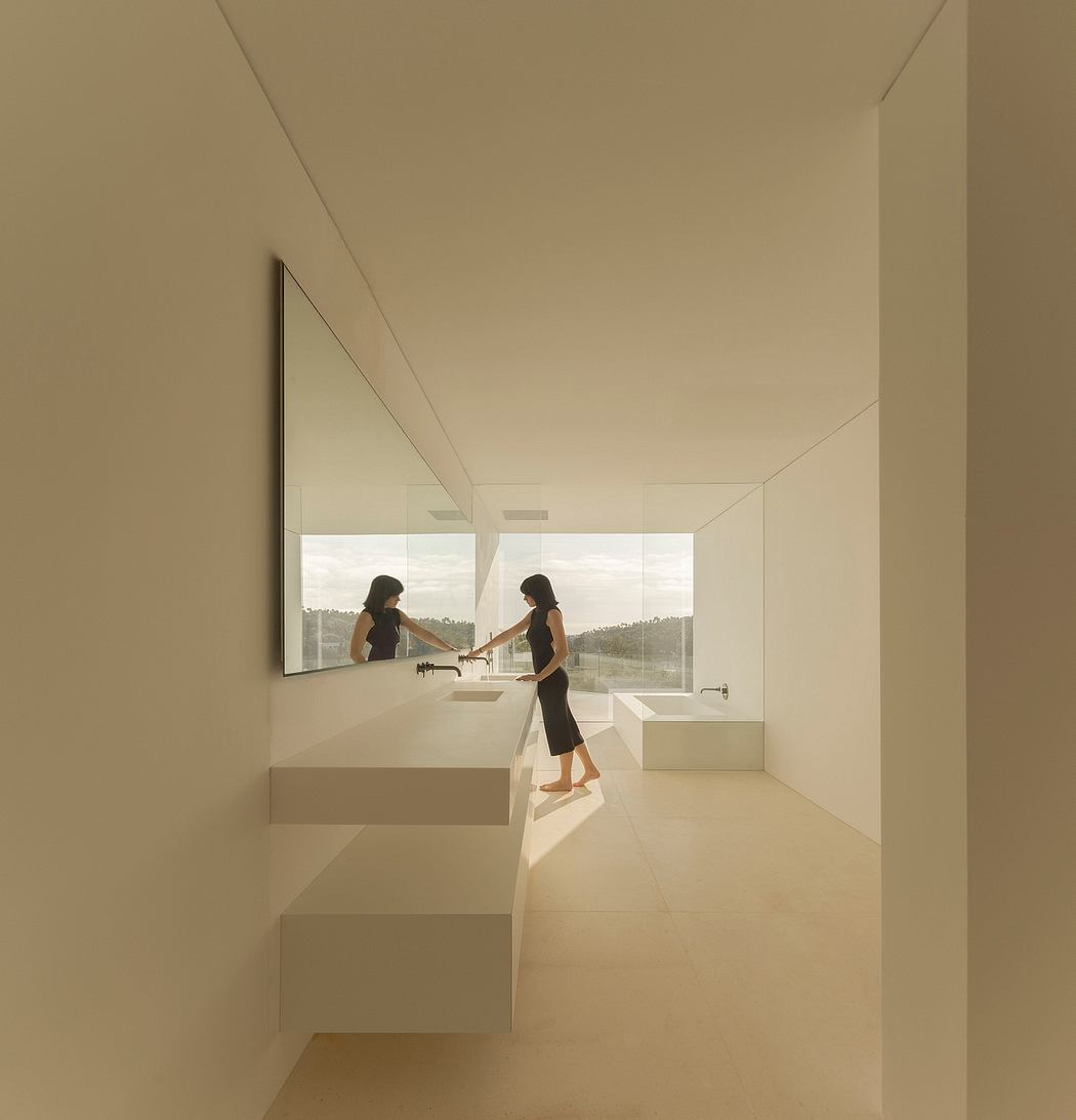 Minimalist bathroom with sleek, modern design, large windows, and floating vanity.