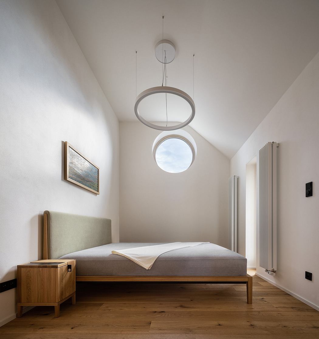 Stylish bedroom with natural wood furniture, circular pendant lights, and arched window.