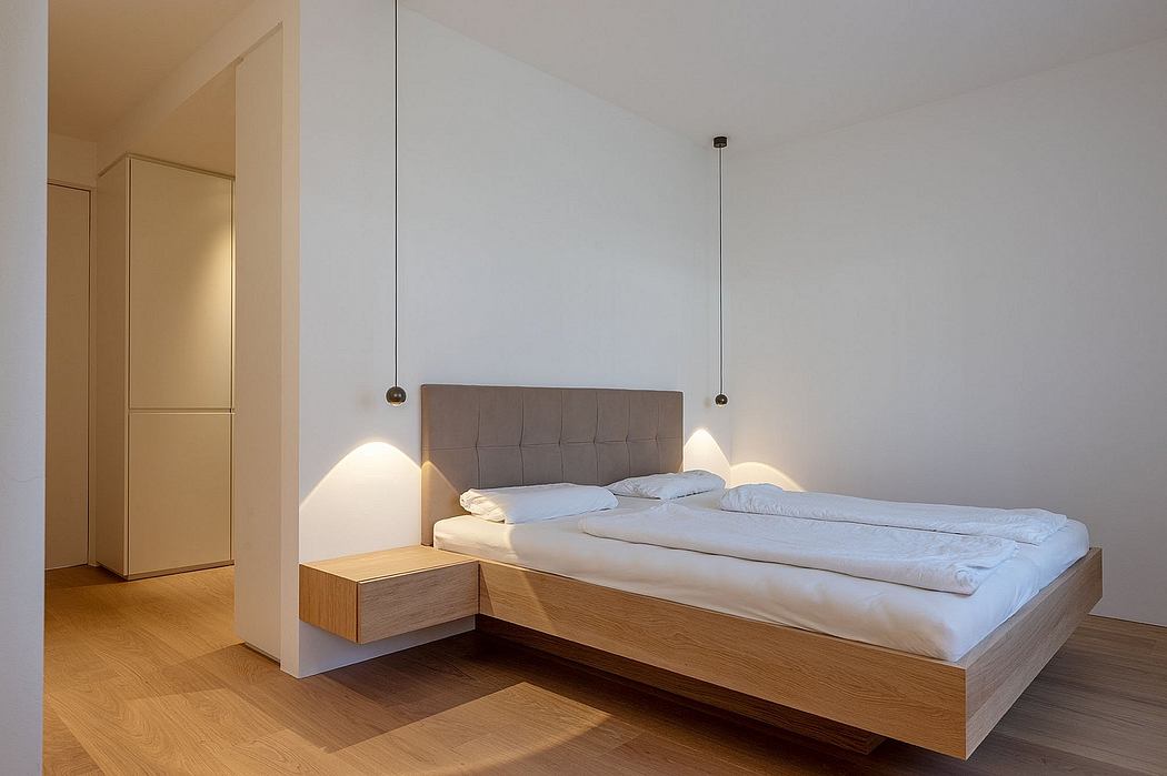 Minimalist bedroom design featuring floating bed platform, pendant lights, and wood accents.