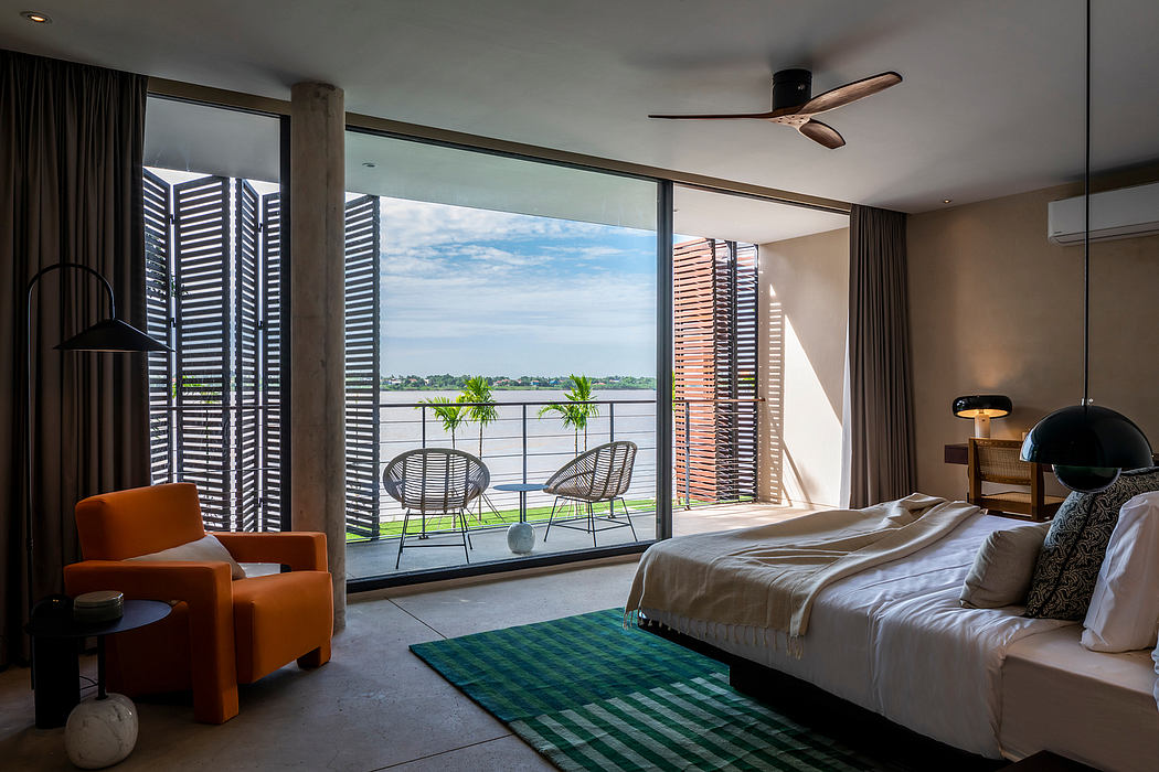 Spacious, modern bedroom with floor-to-ceiling windows, sleek furnishings, and a scenic outdoor view.