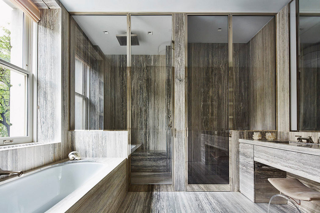 Sleek, modern bathroom with sleek glass shower enclosure and natural stone walls.