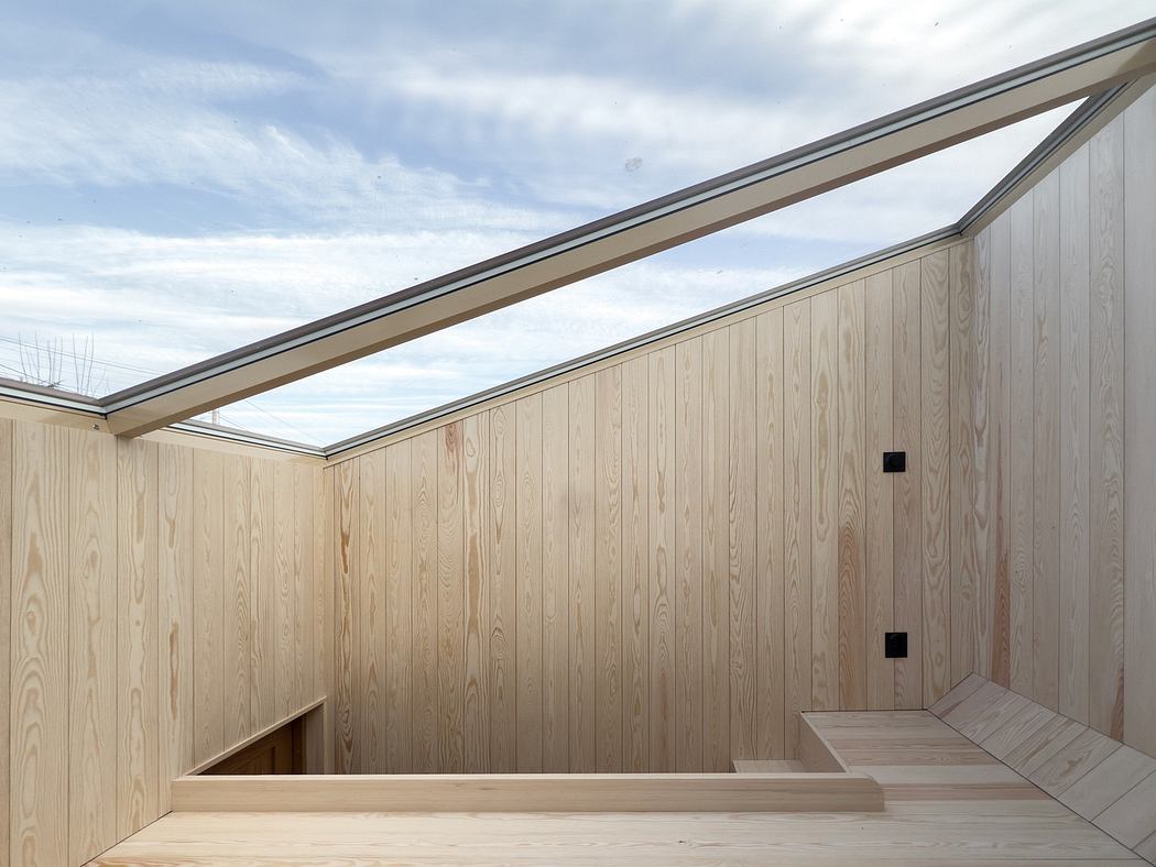 A modern, wooden-paneled interior with a slanted skylight, creating a warm, inviting atmosphere.