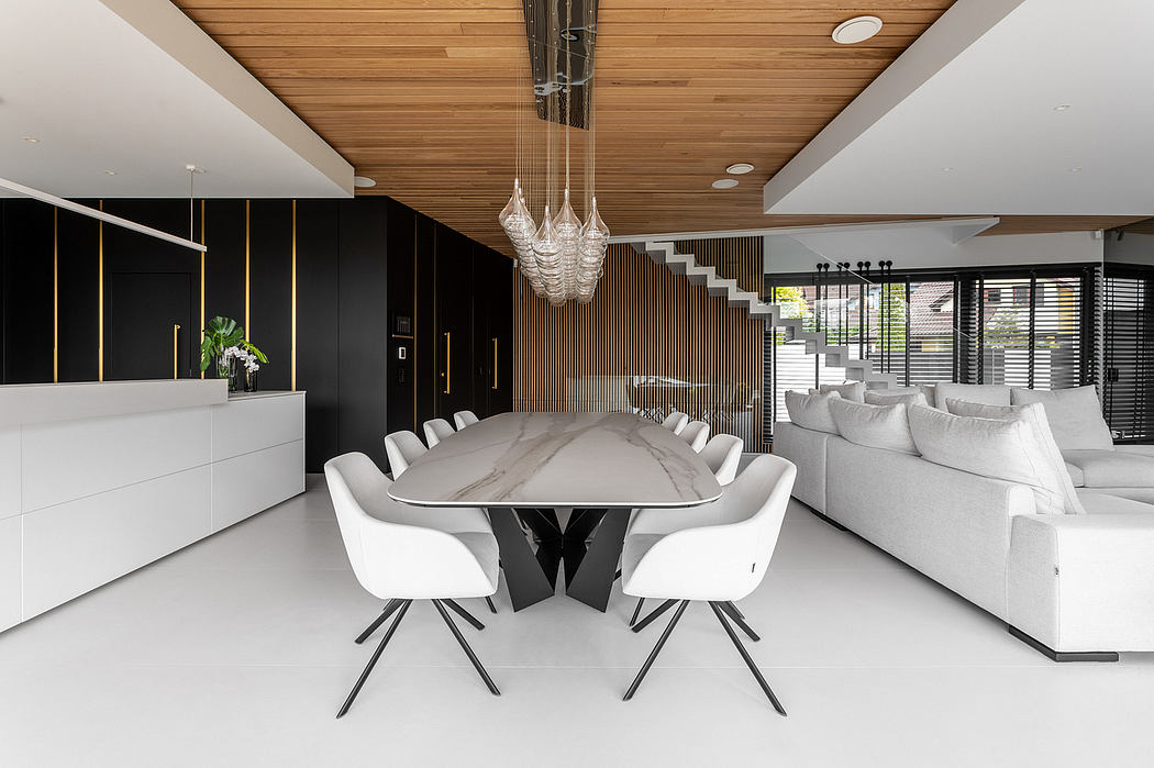 Sleek, modern dining area with a dramatic glass chandelier and black-and-white decor.