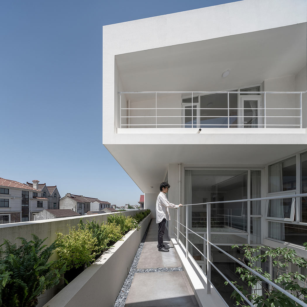 Sleek modern balcony with glass railings overlooking a residential neighborhood.