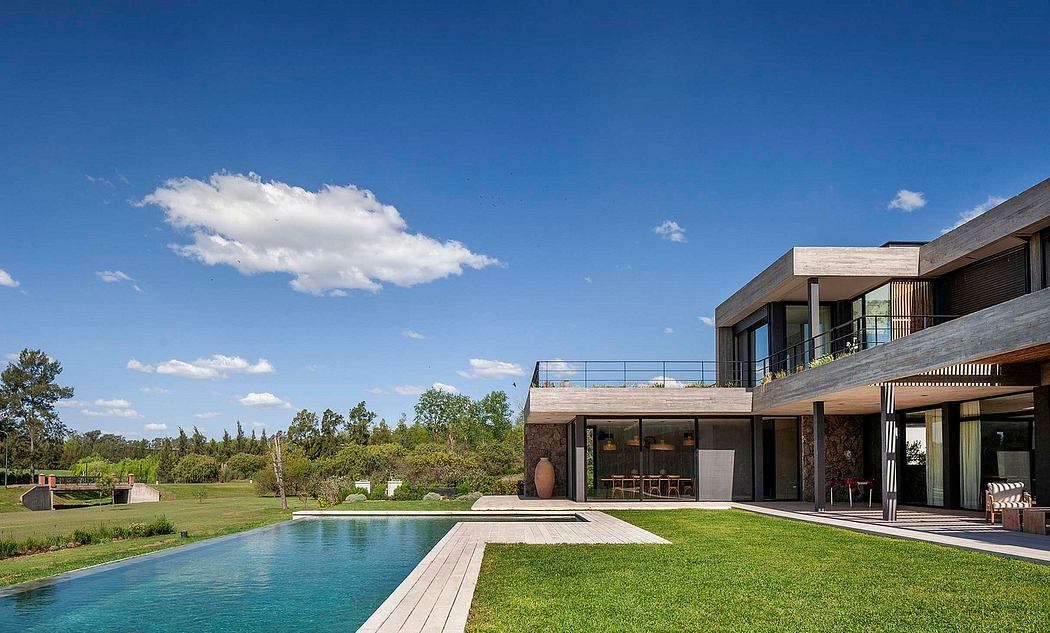 Modern architectural home with large windows, pool, and lush landscaping in natural setting.