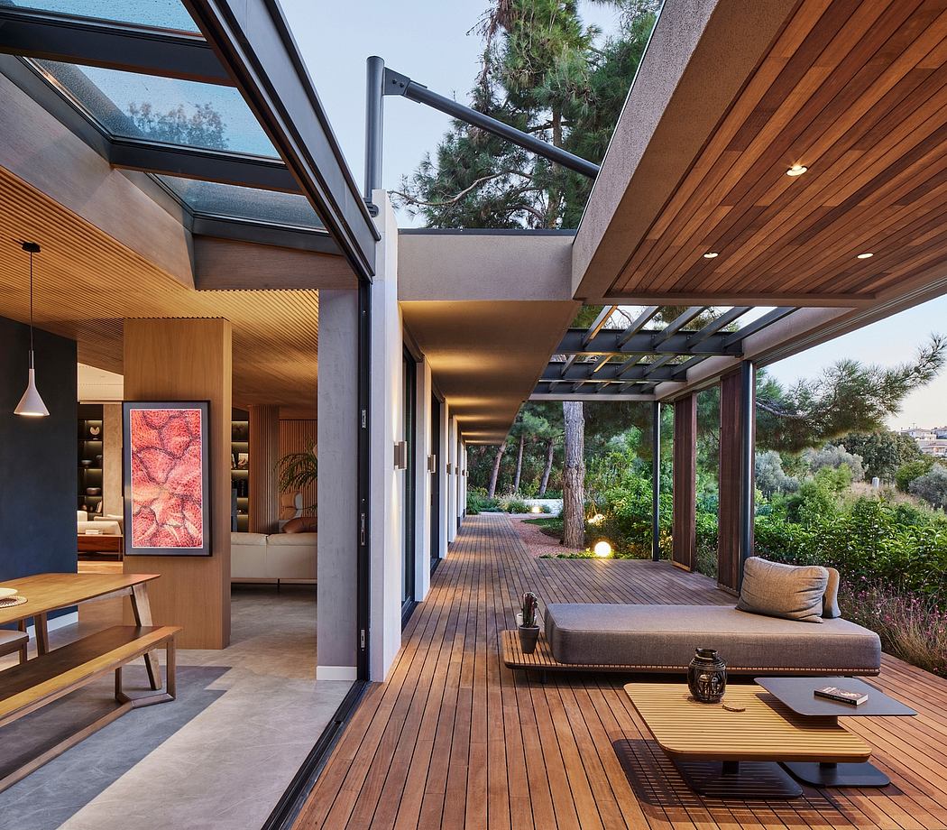 Expansive modern patio with wooden deck, glass walls, and lush outdoor views.