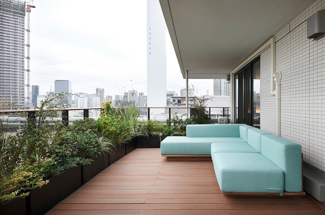 Balcony oasis with lush greenery, modern couch, and scenic city view.