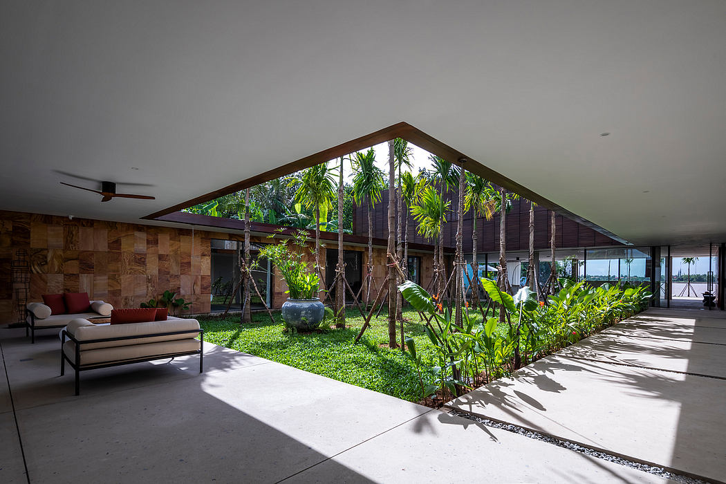 Contemporary tropical architecture with lush indoor garden and sitting area.