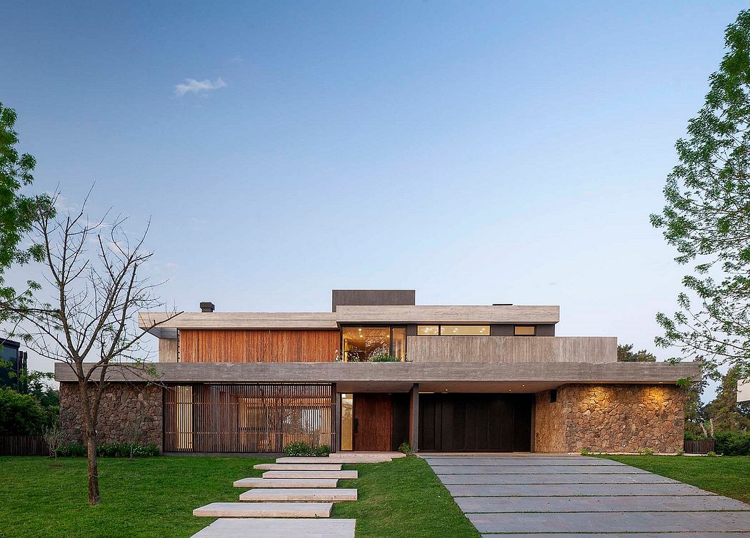 A contemporary, single-story home with stone walls, wood accents, and a flat roof.