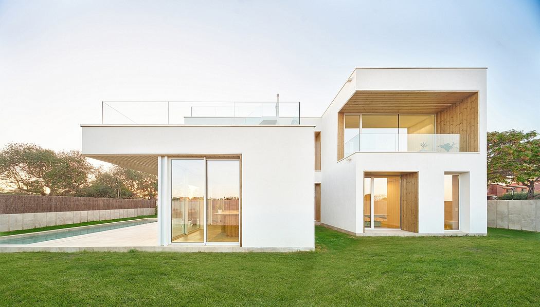 Minimalist modern home design with sleek glass walls, open concept layout, and lush green lawn.