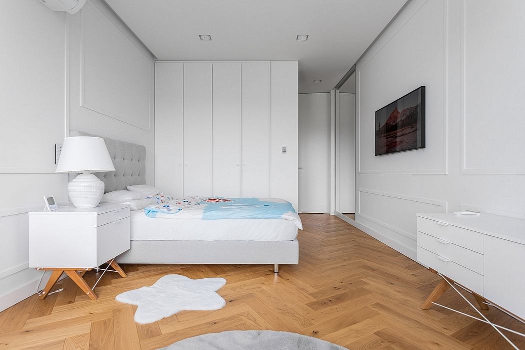 Minimalist bedroom with wood floors, built-in closets, and a gray upholstered bed frame.
