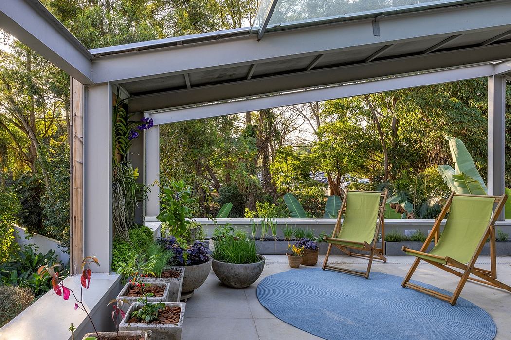 Covered patio with wooden accents, greenery, and comfortable seating overlooking nature.