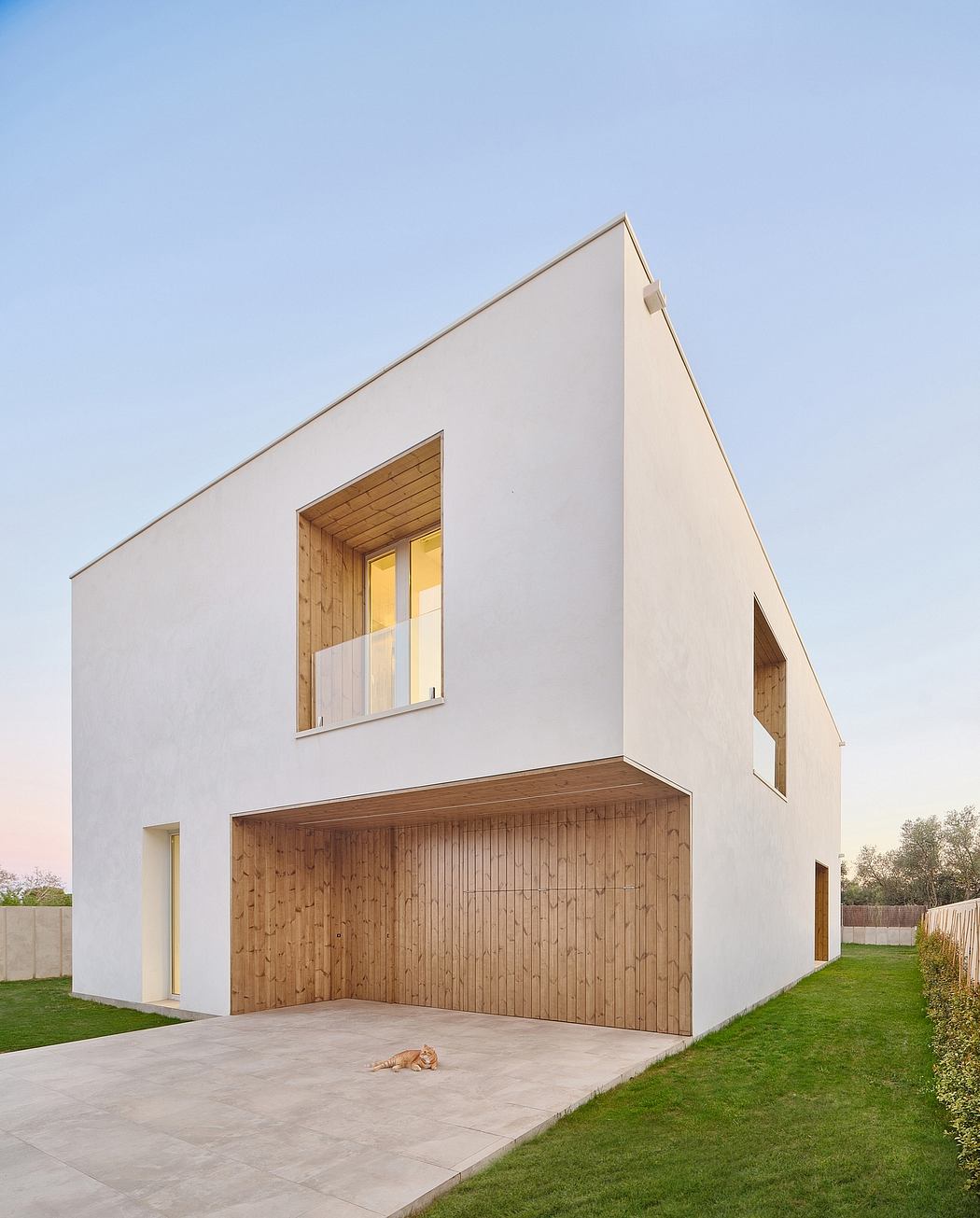 A modern, minimalist house with a striking white facade and contrasting wooden garage door.