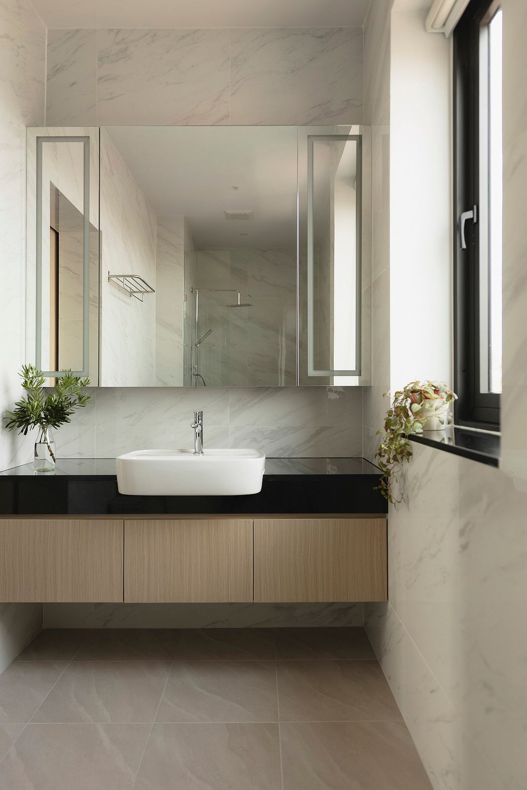 Elegant bathroom design featuring a modern vanity, vessel sink, and large mirrors.