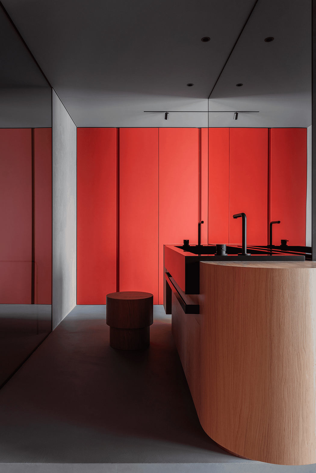 Minimalist interior with bold red panels, wooden vanity, and black fittings.