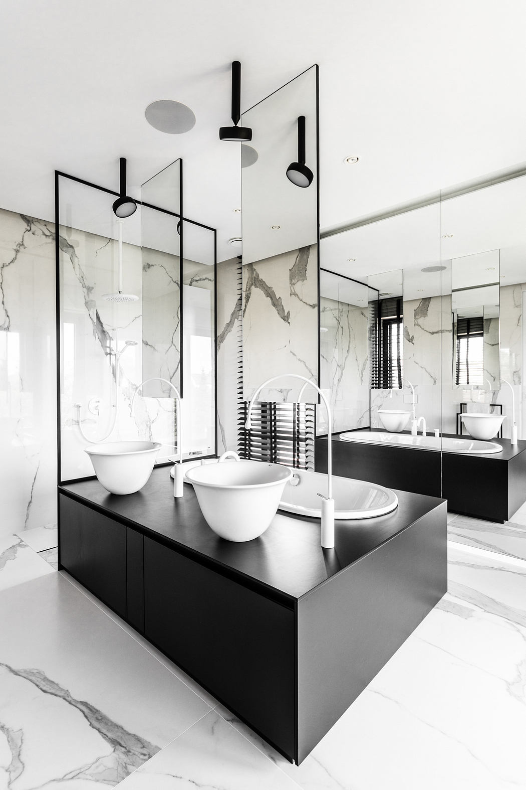 Sleek, minimalist bathroom design with black vanity, marble walls, and geometric lighting.