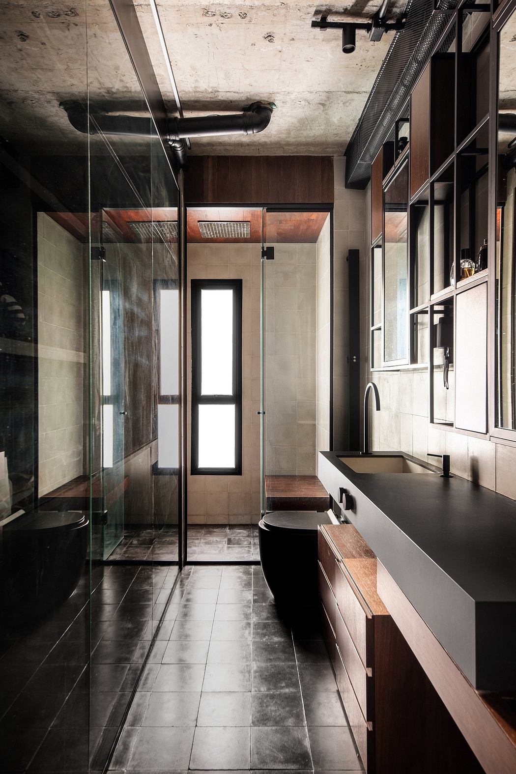 A modern, industrial-inspired bathroom with concrete walls, glass shower, and wooden vanity.