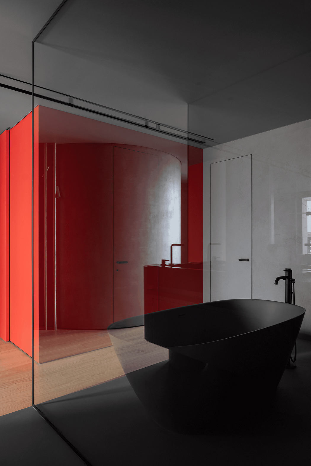 A modern bathroom with a striking black freestanding bathtub, sleek red cabinetry, and frameless glass shower.