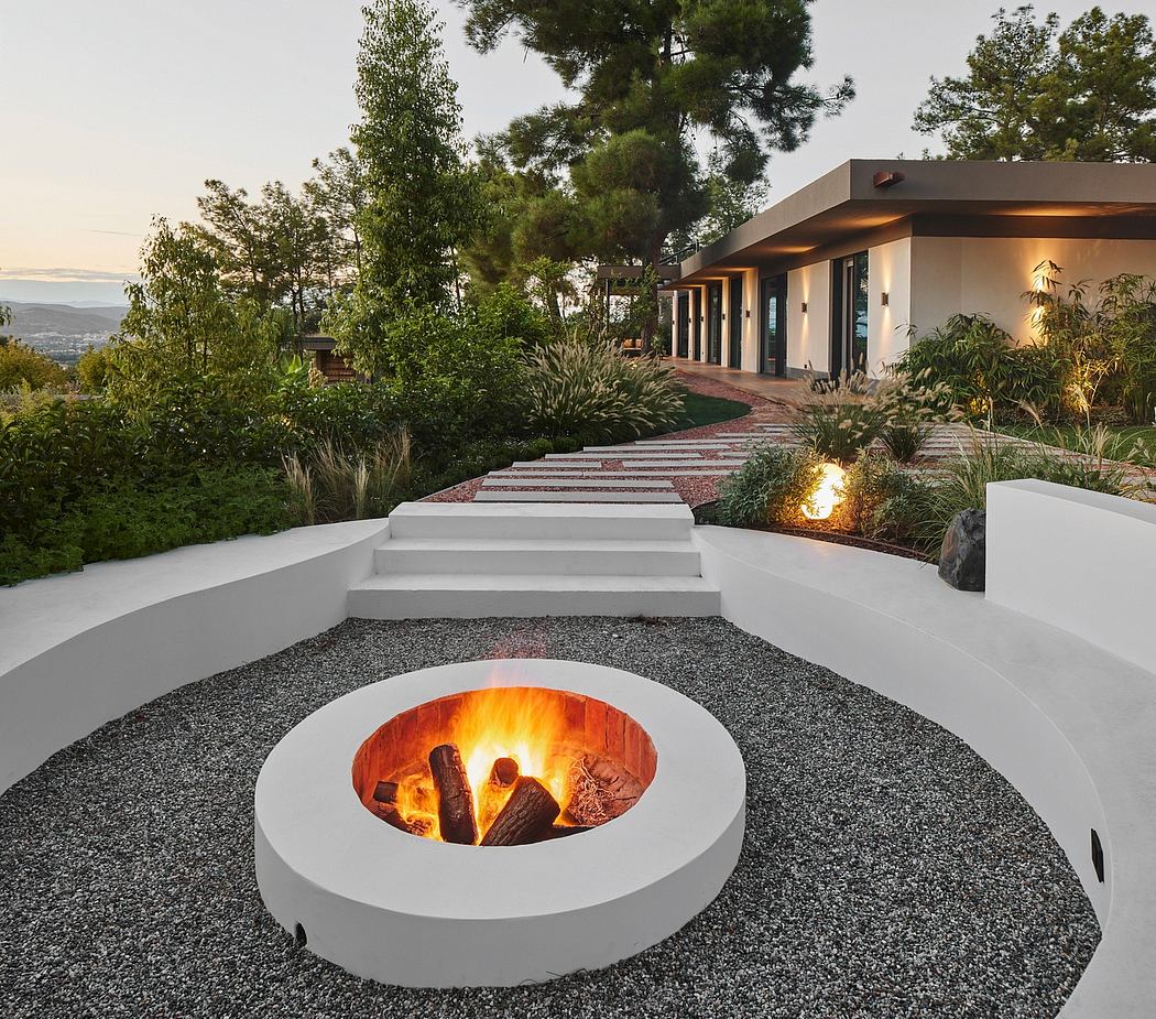 Serene outdoor patio with modern firepit, tiered stairs, and lush greenery.
