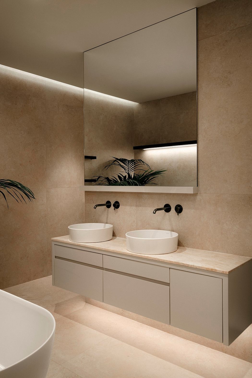 A minimalist bathroom with a vanity, two sinks, and subtle lighting accents.