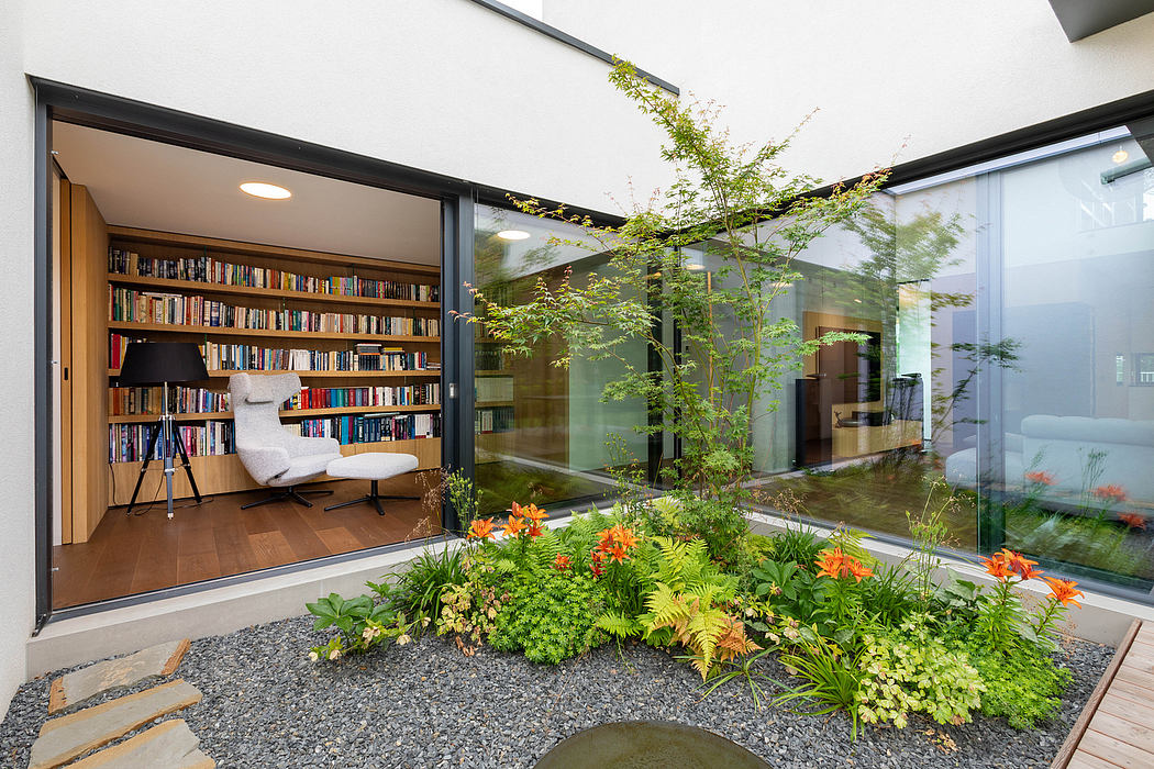 A modern, open-plan home with a glass-enclosed courtyard garden and built-in bookshelves.