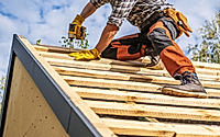 Roofing Contractor Attaching Wooden Elements to the House Roof