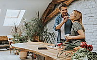 Lovely cheerful young couple cooking dinner together