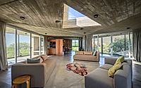 002-casa-cosmos-rammed-stone-and-exposed-concrete-on-a-sloped-site-edge.jpg