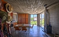 007-casa-cosmos-rammed-stone-and-exposed-concrete-on-a-sloped-site-edge.jpg