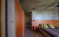 008-casa-cosmos-rammed-stone-and-exposed-concrete-on-a-sloped-site-edge.jpg