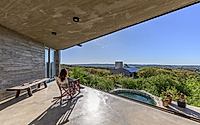 011-casa-cosmos-rammed-stone-and-exposed-concrete-on-a-sloped-site-edge.jpg